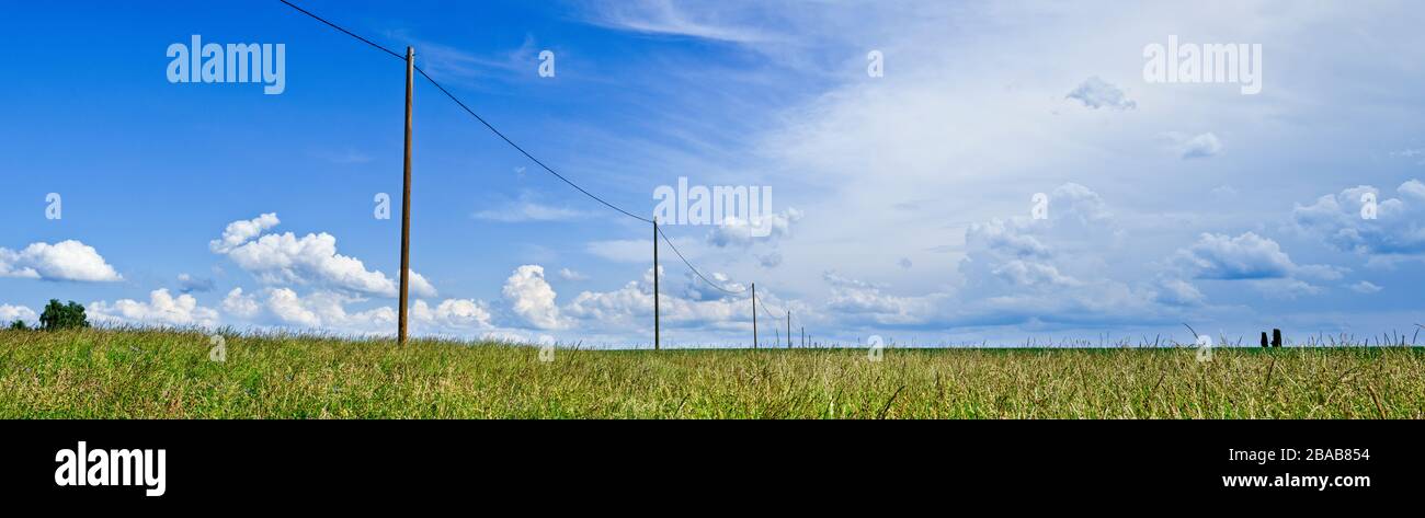 Power lines in field against cloudy sky, Baden Wurttemberg, Germany Stock Photo