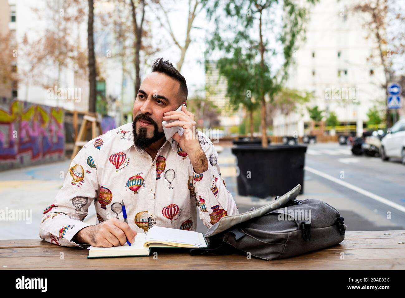 Young bearded businessman sitting at table,using mobile phone Stock Photo