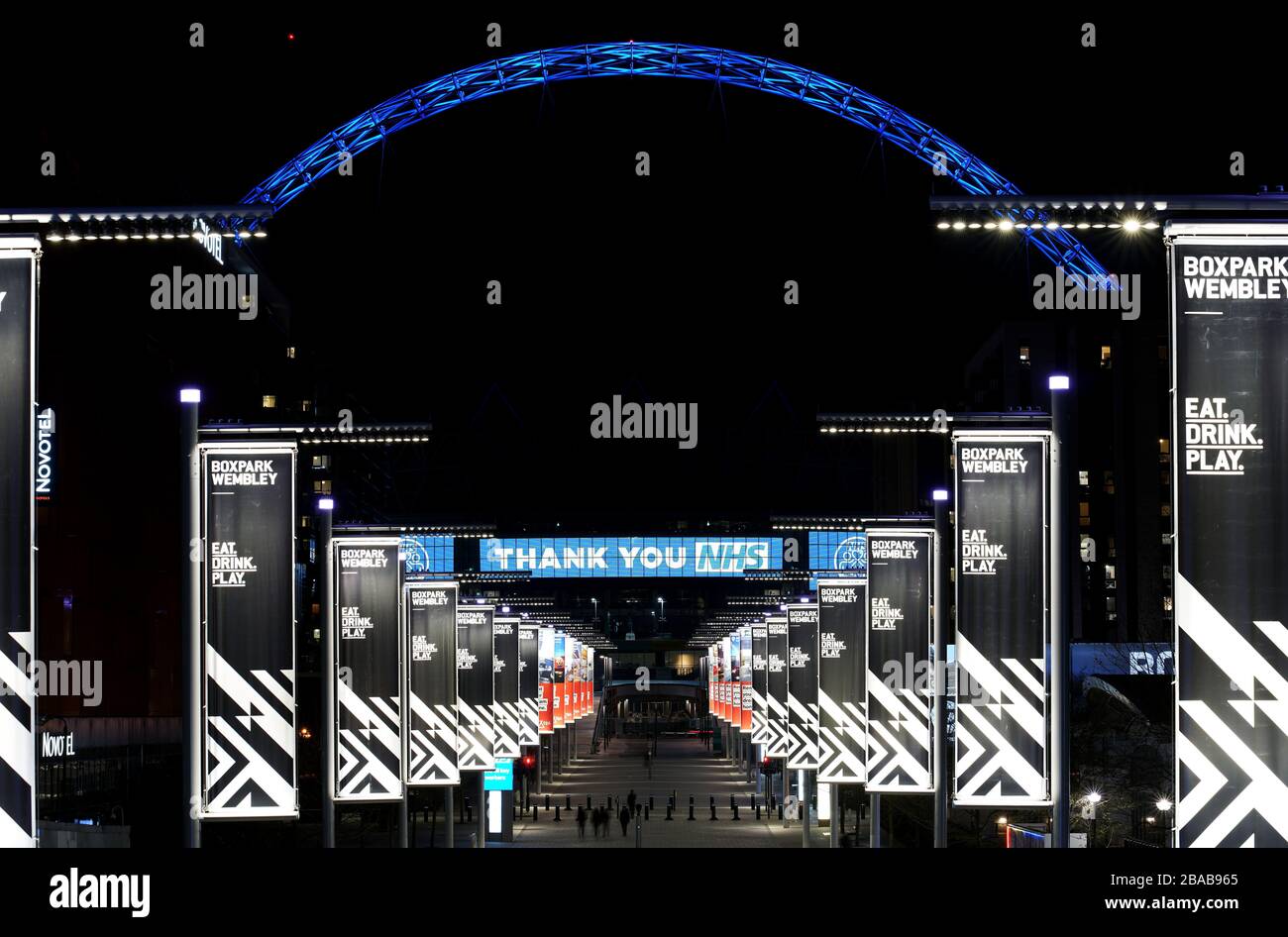 Wembley Arch in London is lit up in blue in a gesture of thanks to the hardworking NHS staff who are trying to battle coronavirus. A national salute for the frontline healthcare heroes is taking place across the UK with a mass round of applause from doorsteps, windows and balconies on Thursday at 8pm. Stock Photo