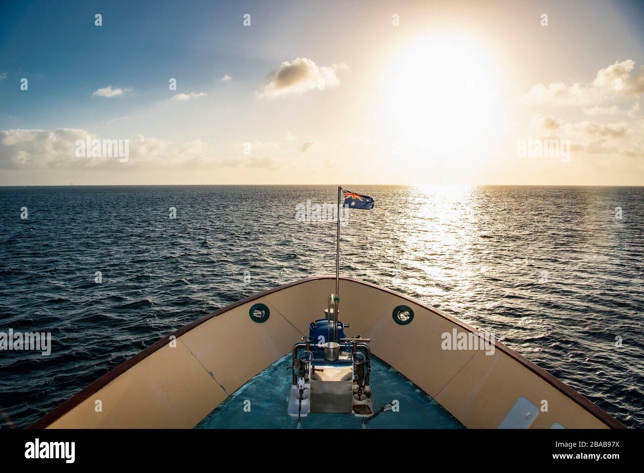 Australian exploration vessel heading into the setting sun Stock Photo