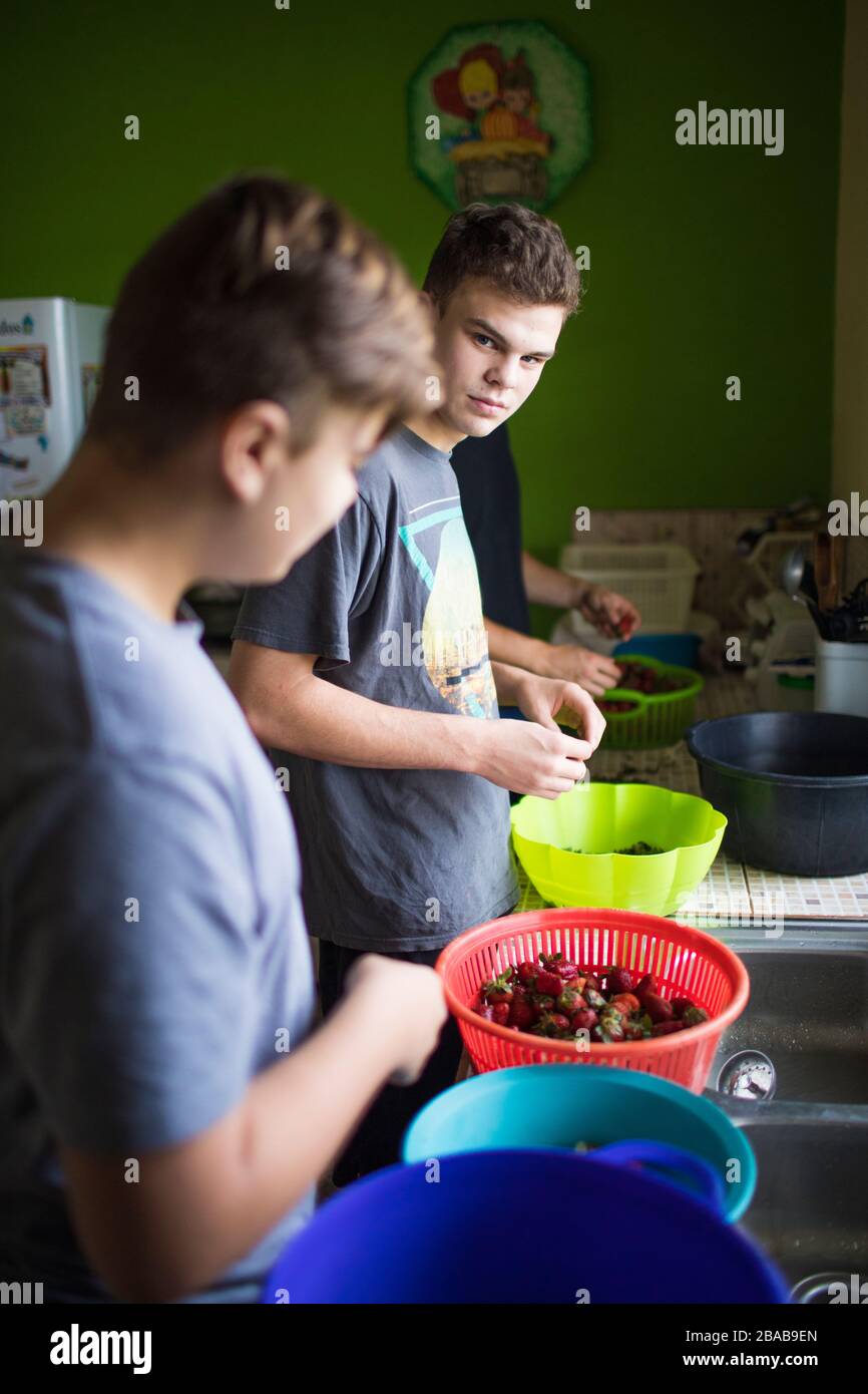 Two young men preparing food in kitchen Stock Photo