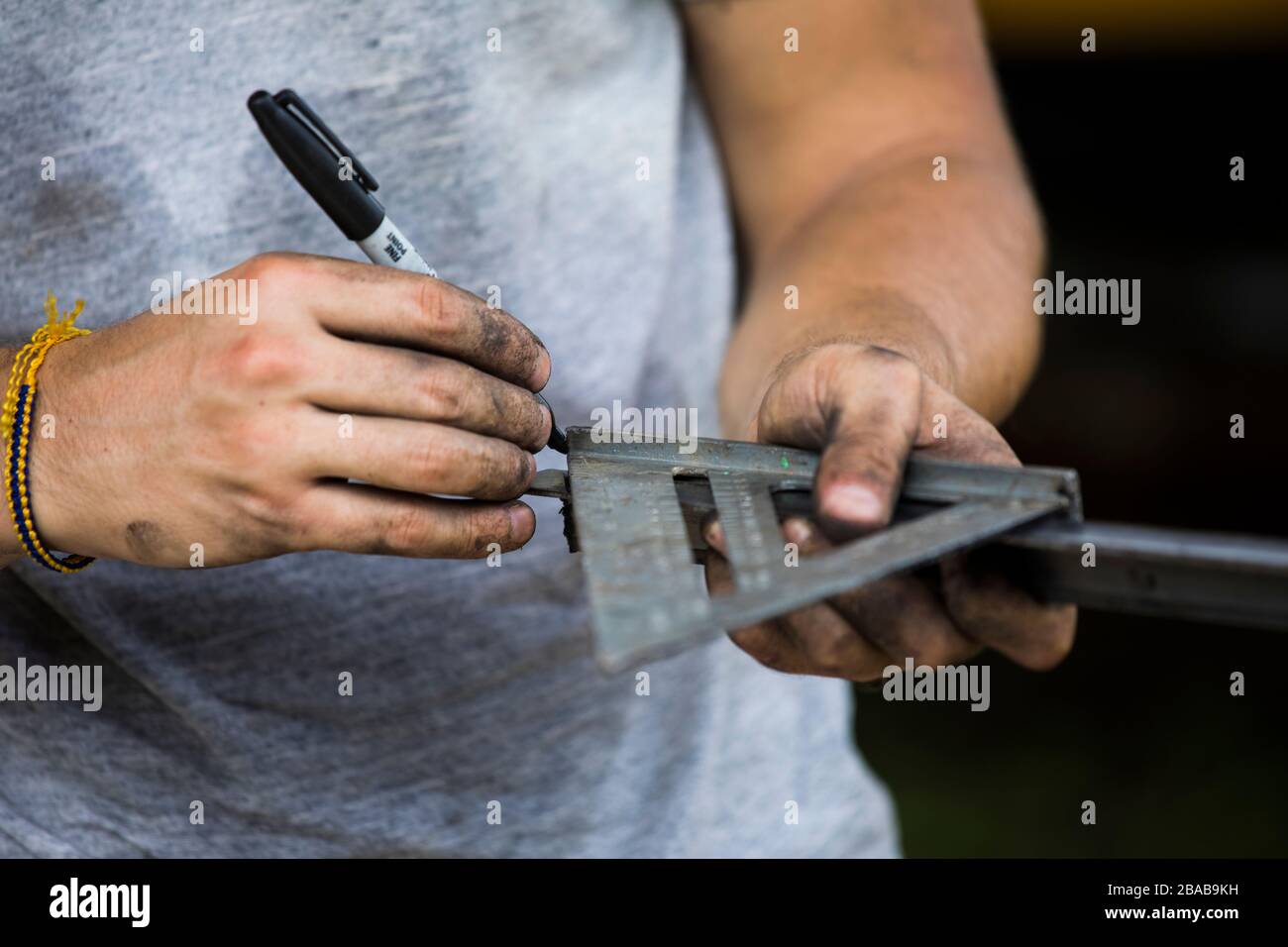 Construction worker using speed square to measure angle on steel. Stock Photo