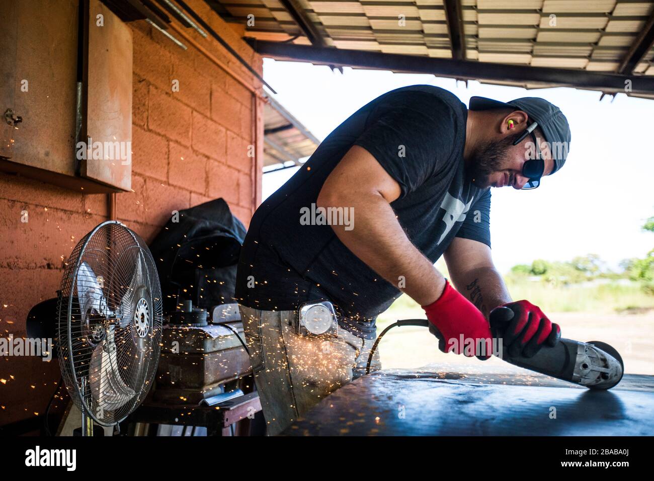 Worker concentrating, using angle grinder to cut steel Stock Photo Alamy