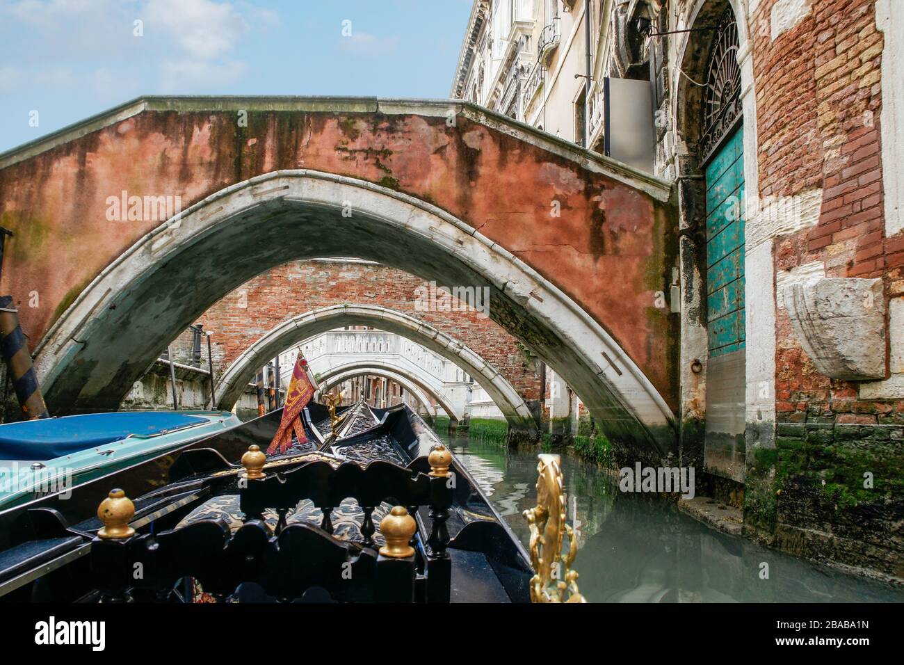 View while riding in a gondola iapproaching four of the typical arched bridges and buildings along the sides. Venice, Italy. Stock Photo