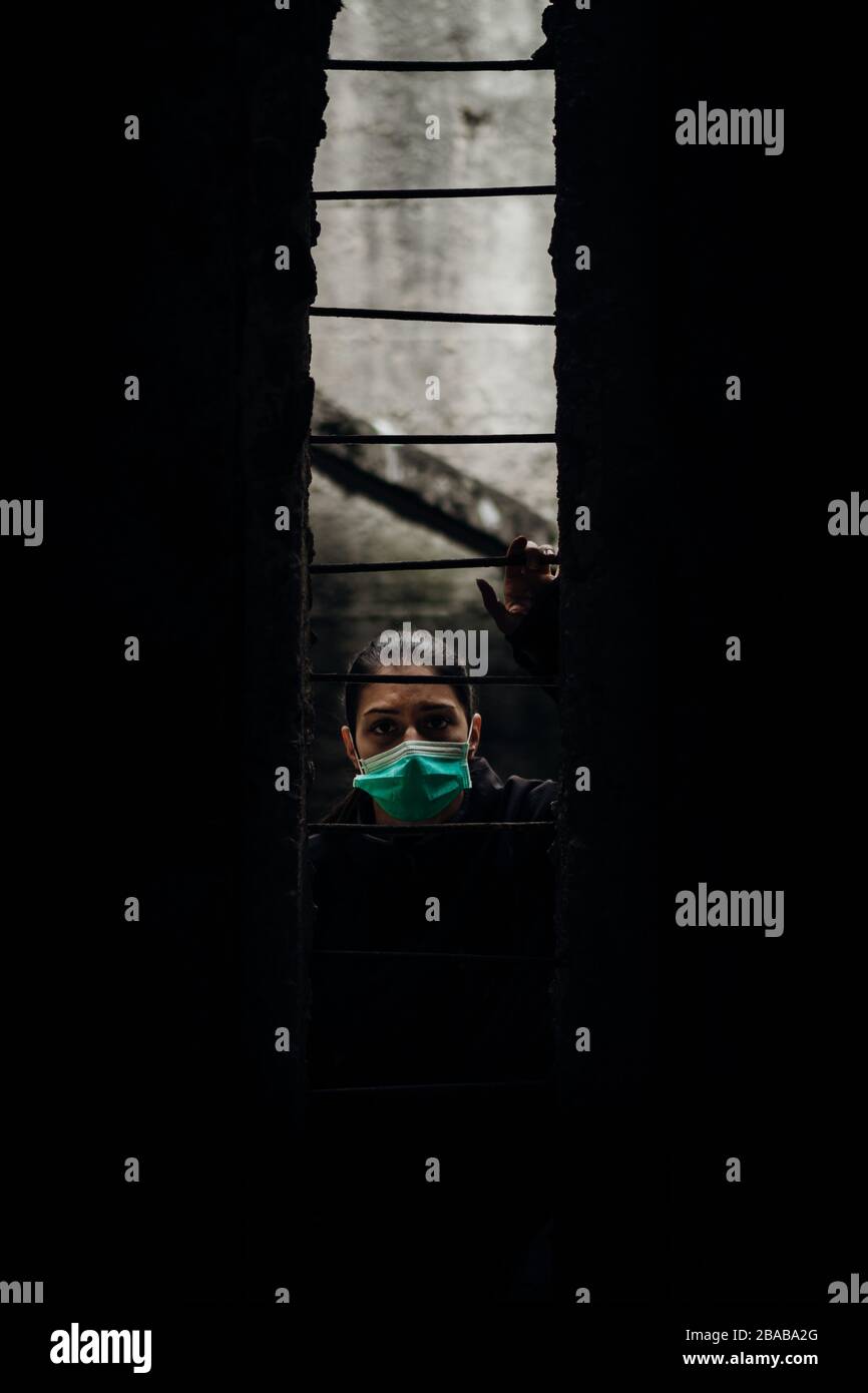 Patient quarantined for contagious lethal disease.Isolation.Prison during epidemic.Person wearing surgical protective mask in quarantine. Stock Photo