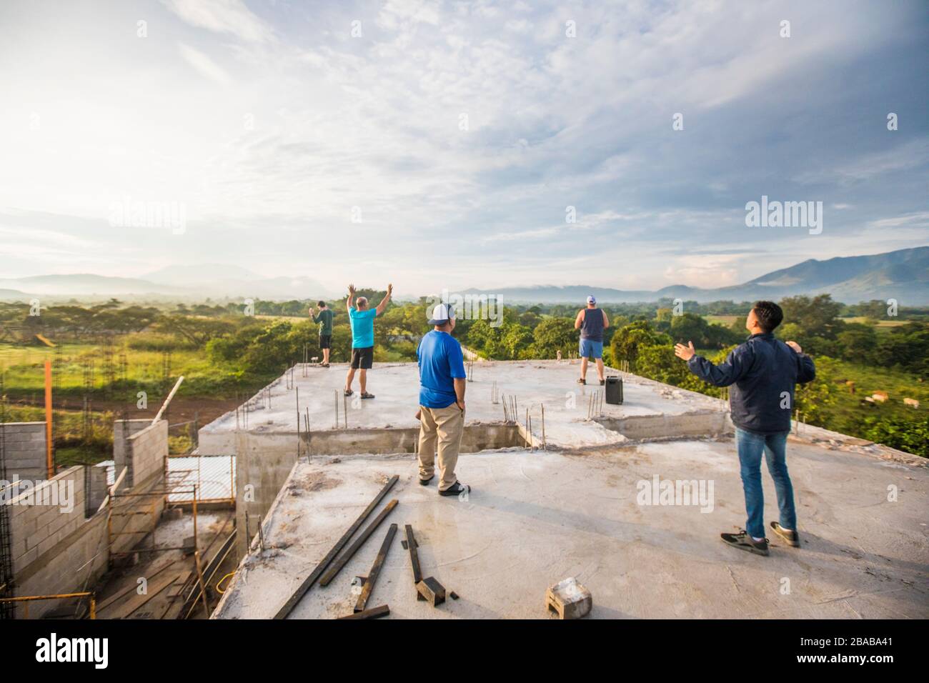 Group of men praising God from rooftop in the morning. Stock Photo