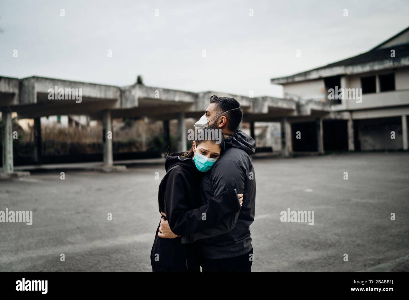 Two people in masks hugging.Couple being divided by incurable infectious disease.Infection control,isolation.Loved one illness.Saying goodbye.Farewell Stock Photo