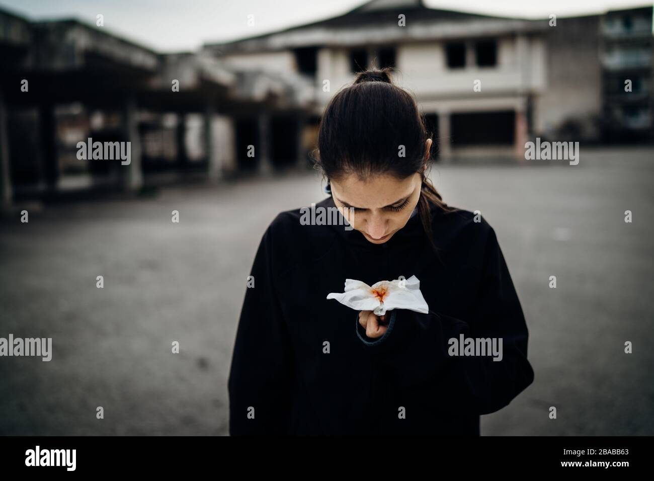 Sick woman holding bloody tissue.Cough with blood.Infectious disease victim.Ill person having lethal respiratory disease.Attacked immune system.Sympto Stock Photo