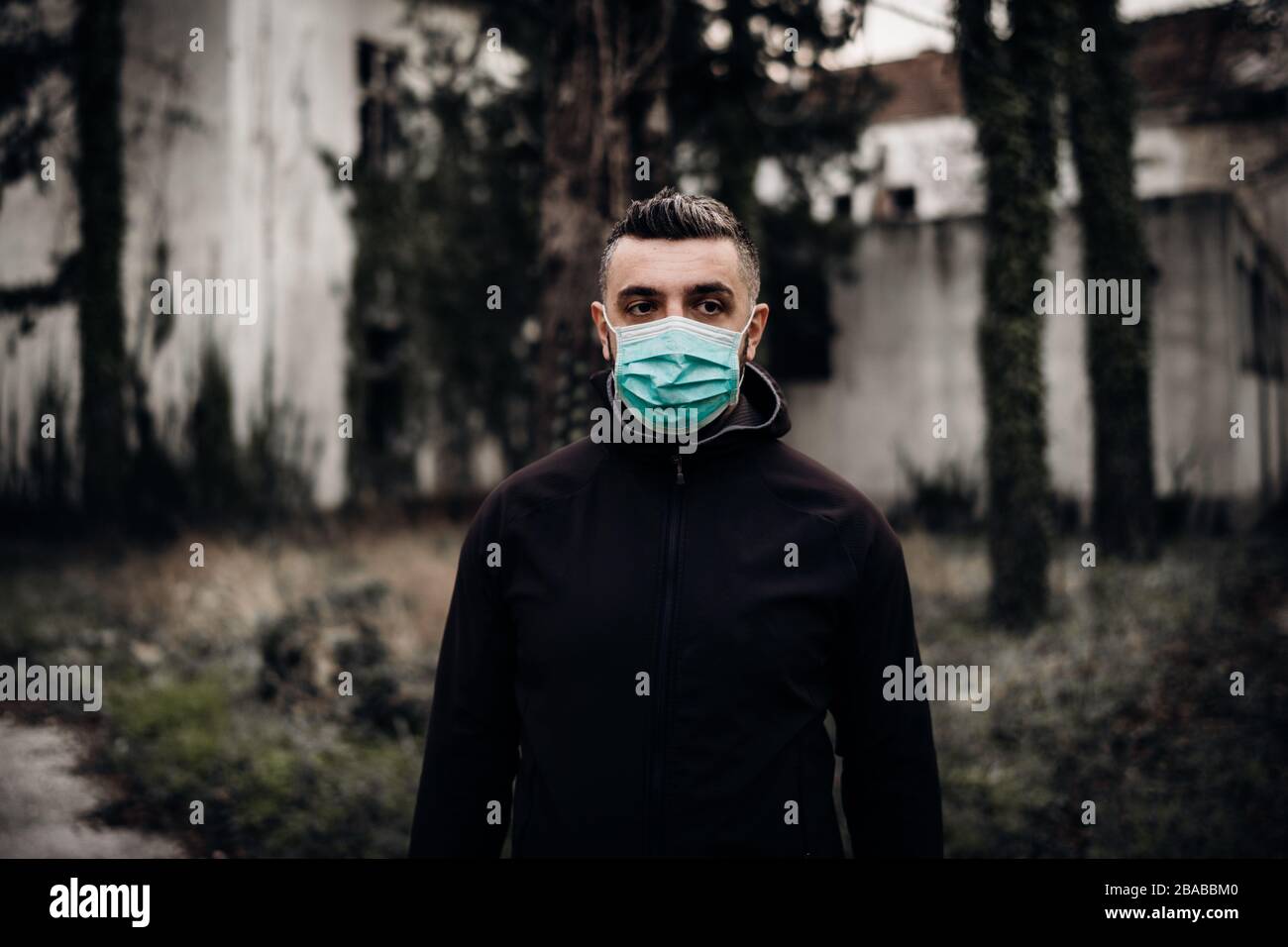 Concerned man wearing a protective mask.Activities in time of epidemic/pandemic.Panic and fear of infection.Life in contaminated area.Actions for prev Stock Photo