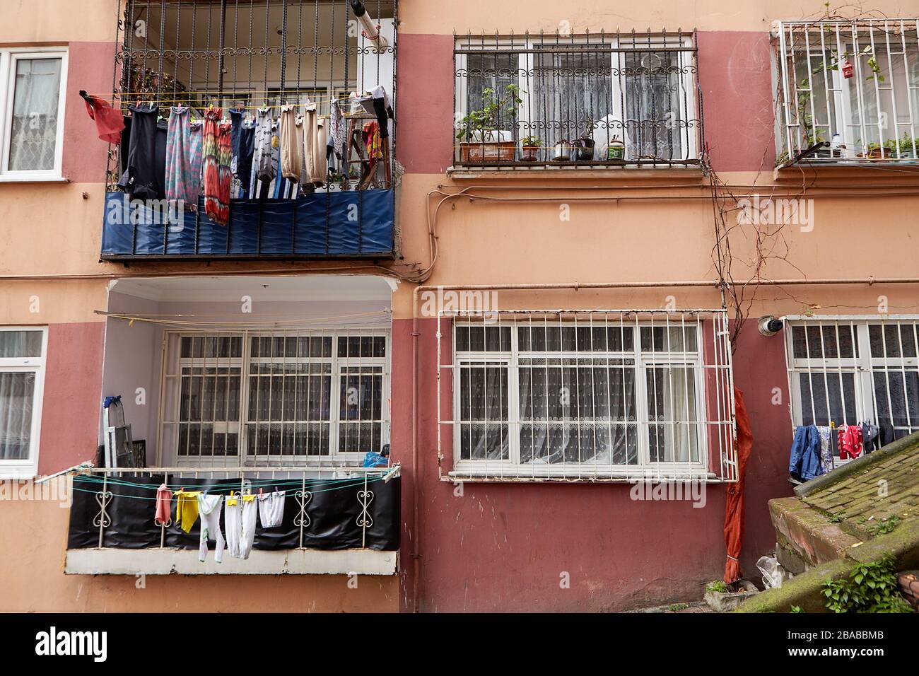 Istanbul, Turkey - February 12, 2020: The facade of an apartment building with barred windows and ropes for drying wet clothes in the open air. Stock Photo
