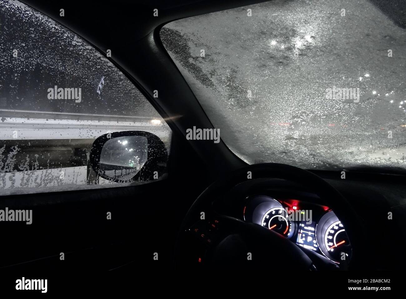 Ice And Snow On The Frozen Windshield Of Car On The Night Road Stock Photo