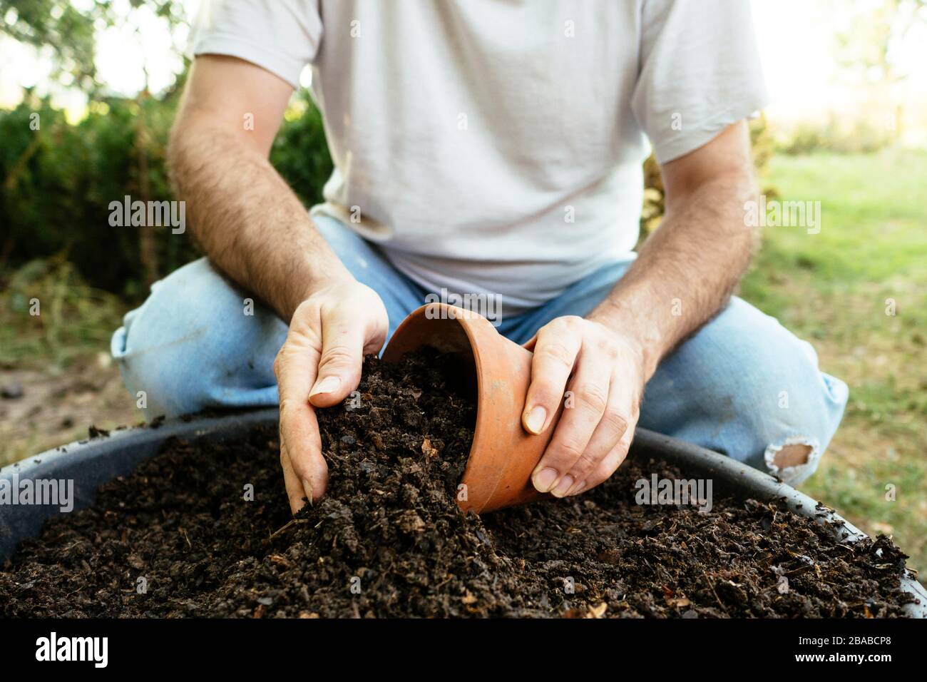 Gardener filling a pot with fresh compost Stock Photo