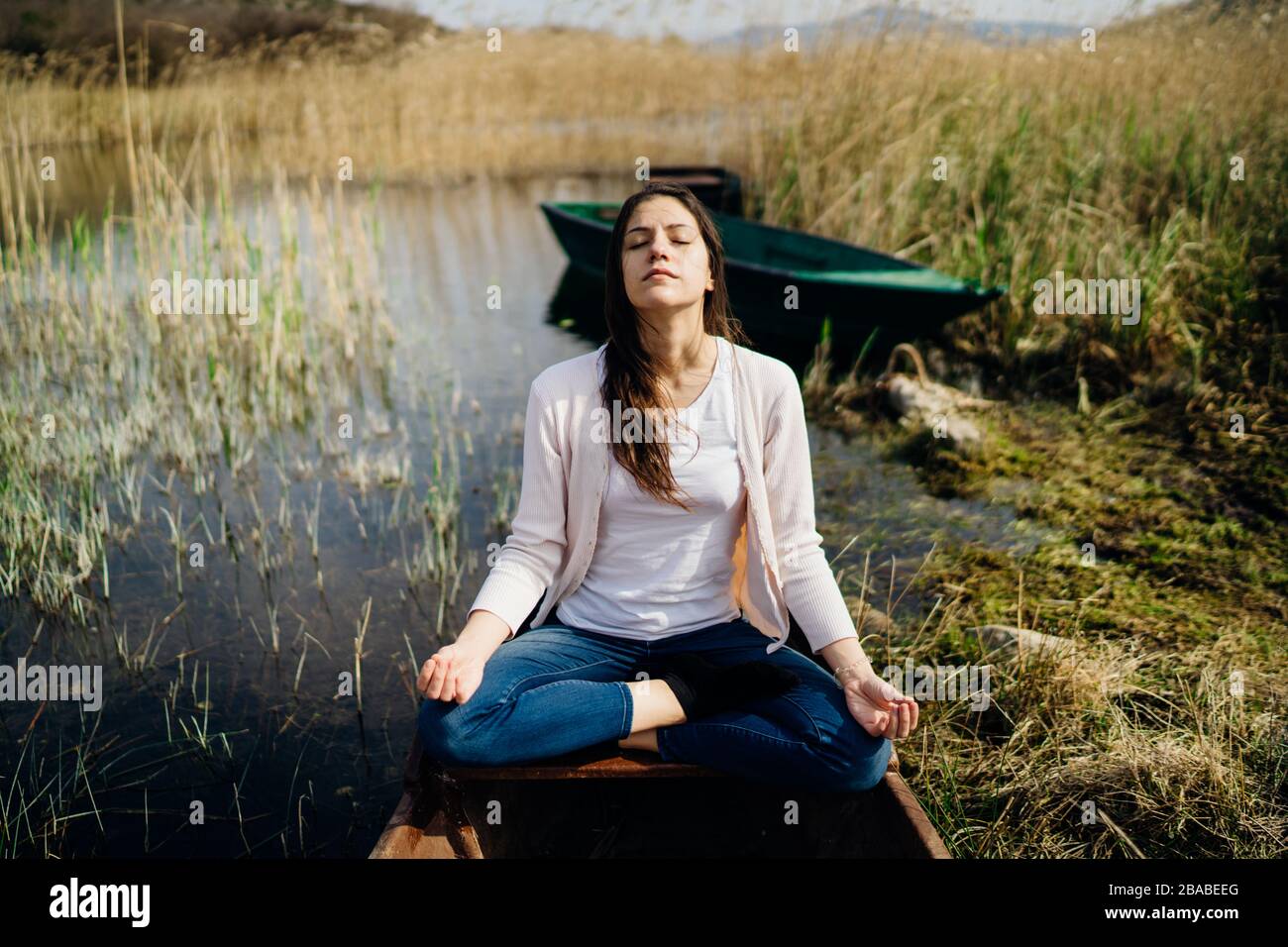 Woman meditating in nature.Escape from stressful reality.Mindful woman practicing meditation.Breathing technique.Mental state issues menagement. Stock Photo