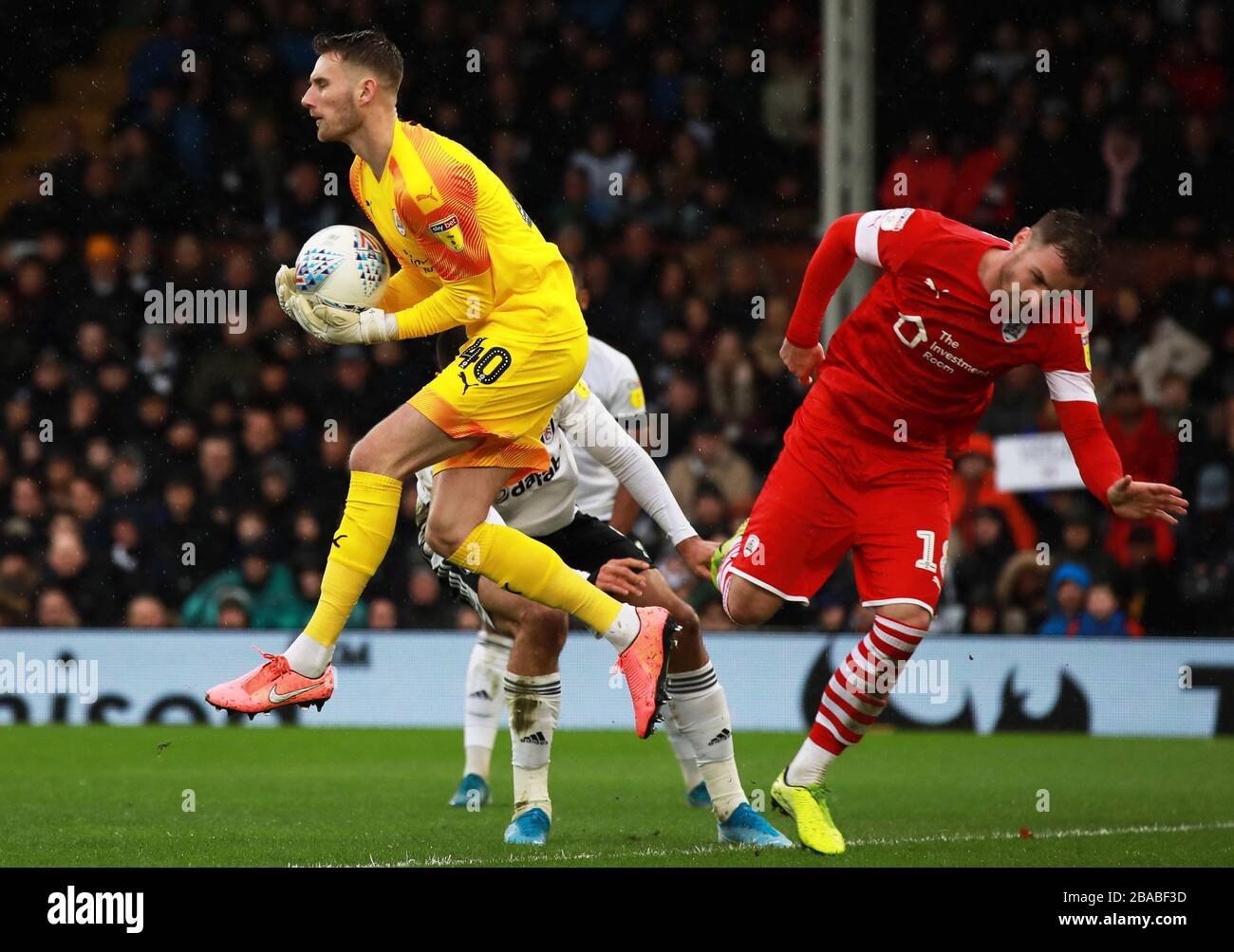 Barnsley goalkeeper Brad Collins (left) catches the ball Stock Photo