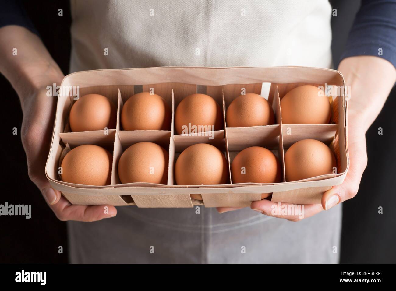 Raw chicken eggs in woman's hands. Stock Photo