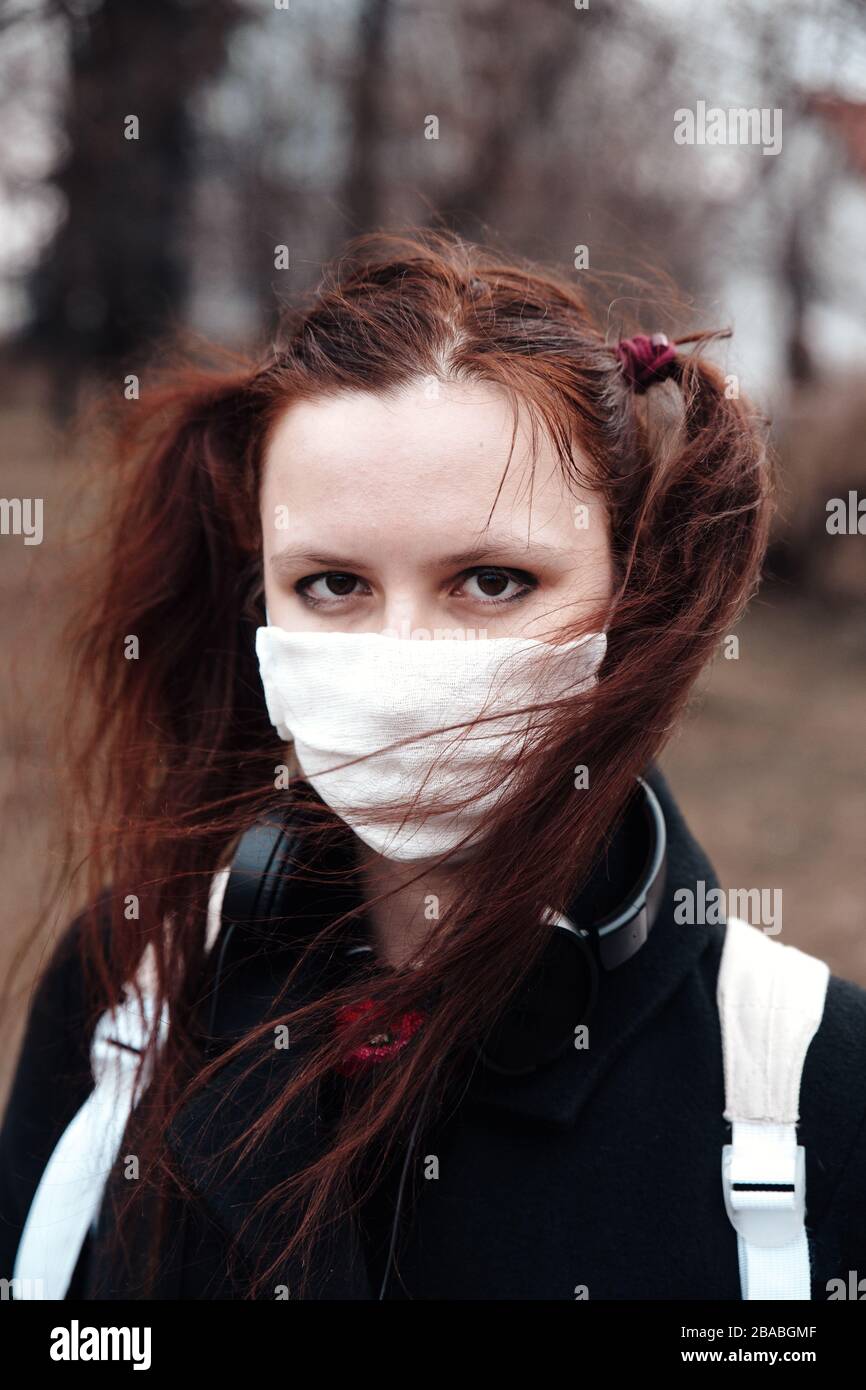 Close-up of young woman with surgical mask on face against SARS-CoV-2 and Coronavirus Stock Photo