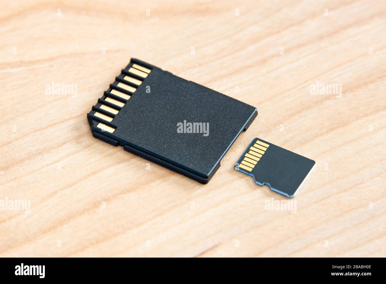 A SD memory card on a wooden surface. Stock Photo