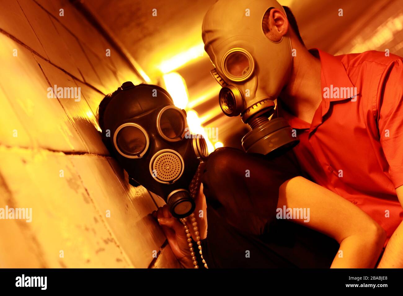 Married couple in gas masks in a tunnel Stock Photo
