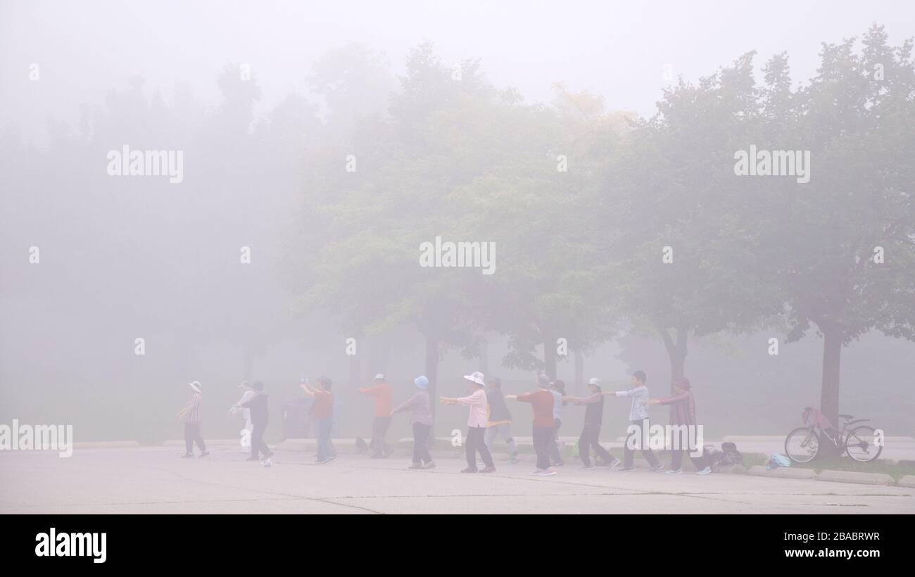 Senior adults exercising  in foggy morning Stock Photo