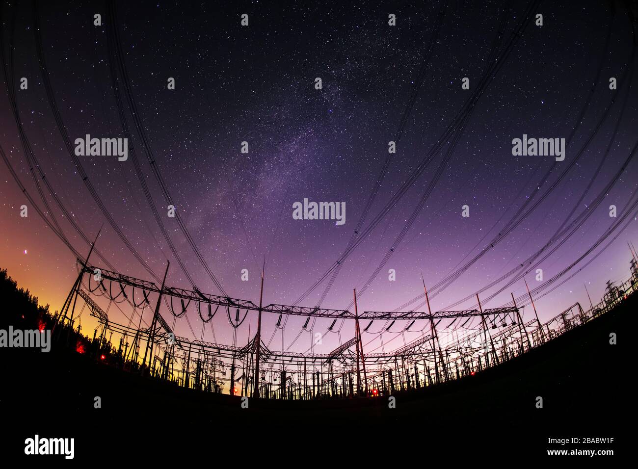 High voltage towers at night and the Milky Way Stock Photo