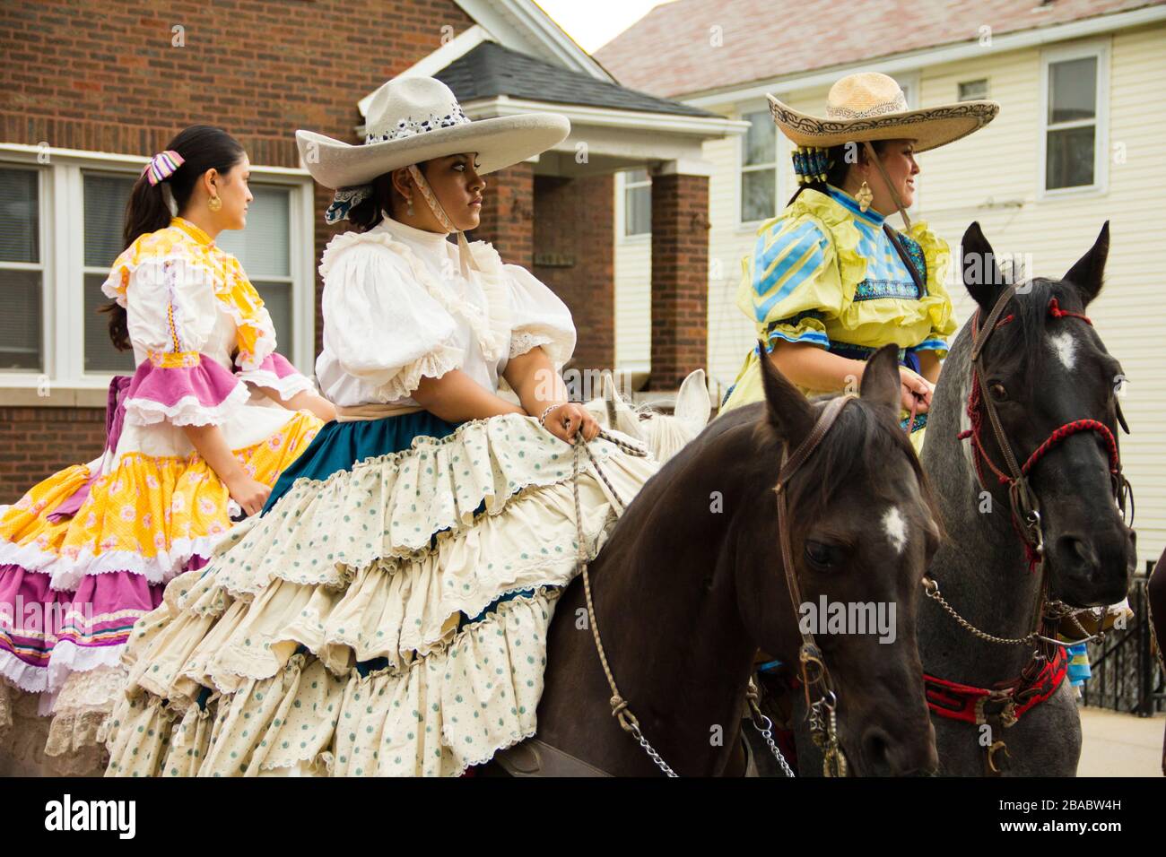 Street parade, Women in colorful dresses riding on horses, Pilsen, Chicago, Illinois, USA Stock Photo