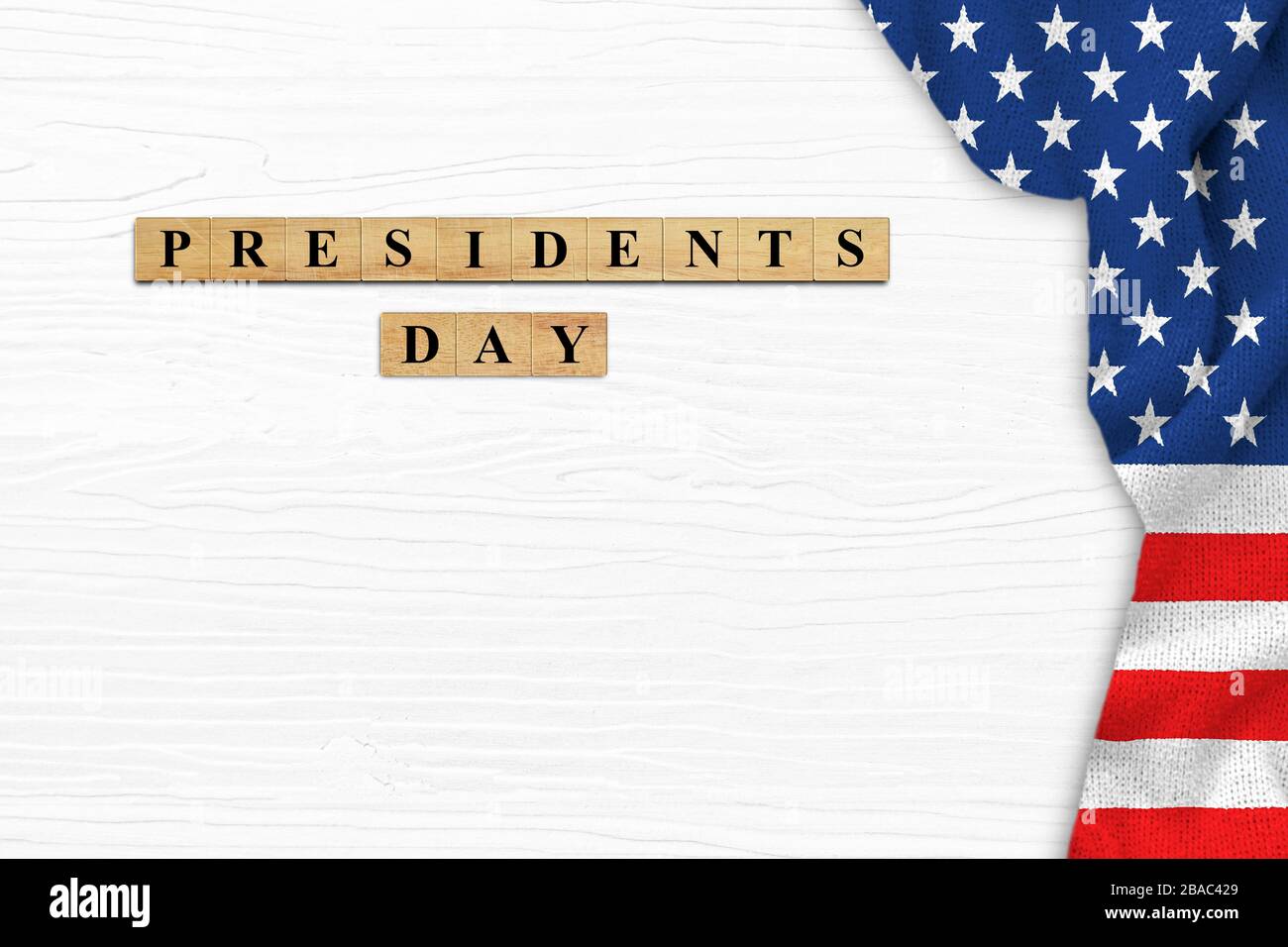 Happy Presidents' Day on white wood background with American flag