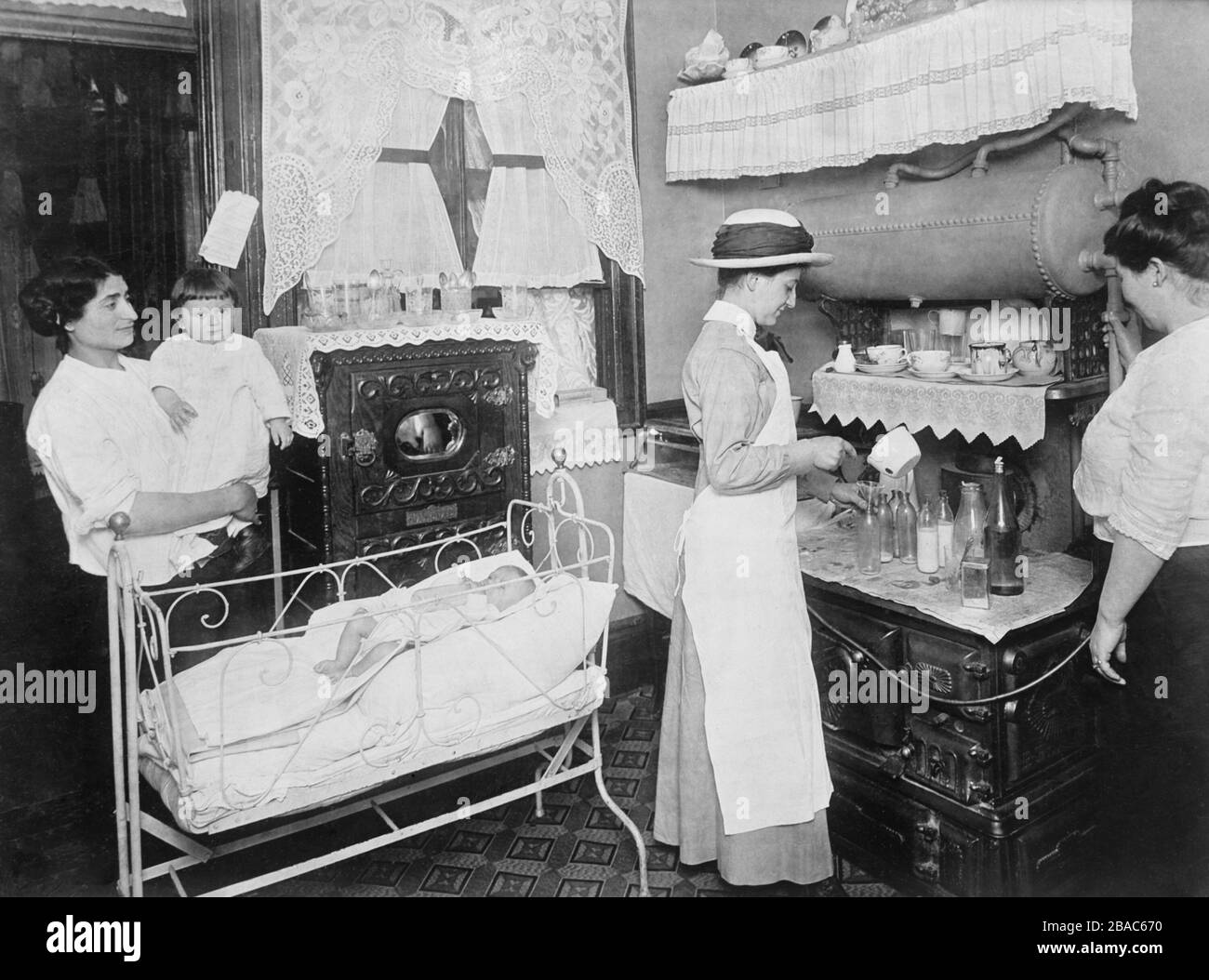 Public health nurse instructs a mother in the preparation of milk ...