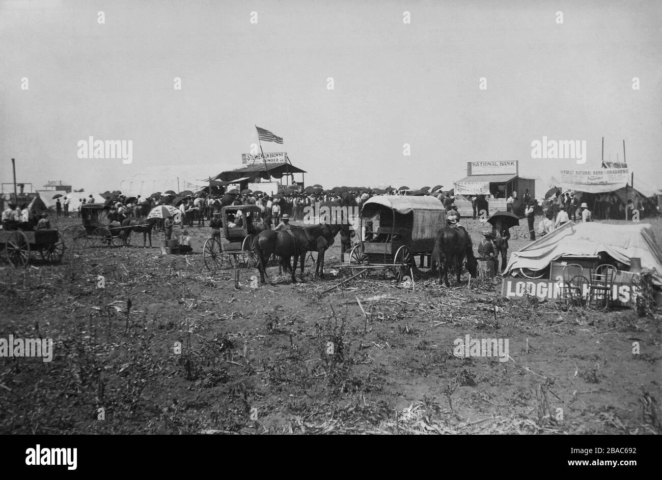 Land auction in progress at the lumber company booth, with banks