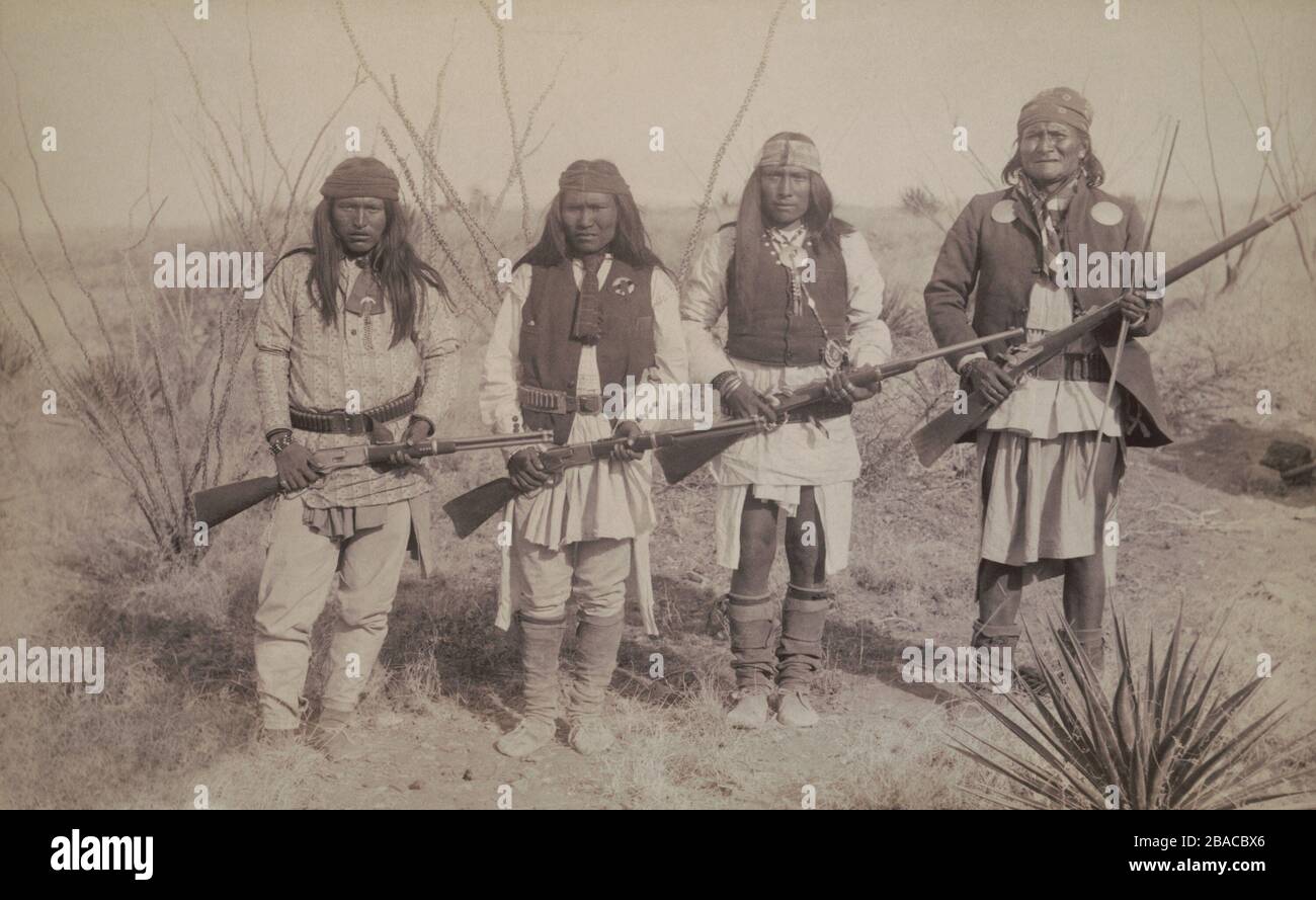 Geronimo, standing on the right, holding a long rifle, with a son and