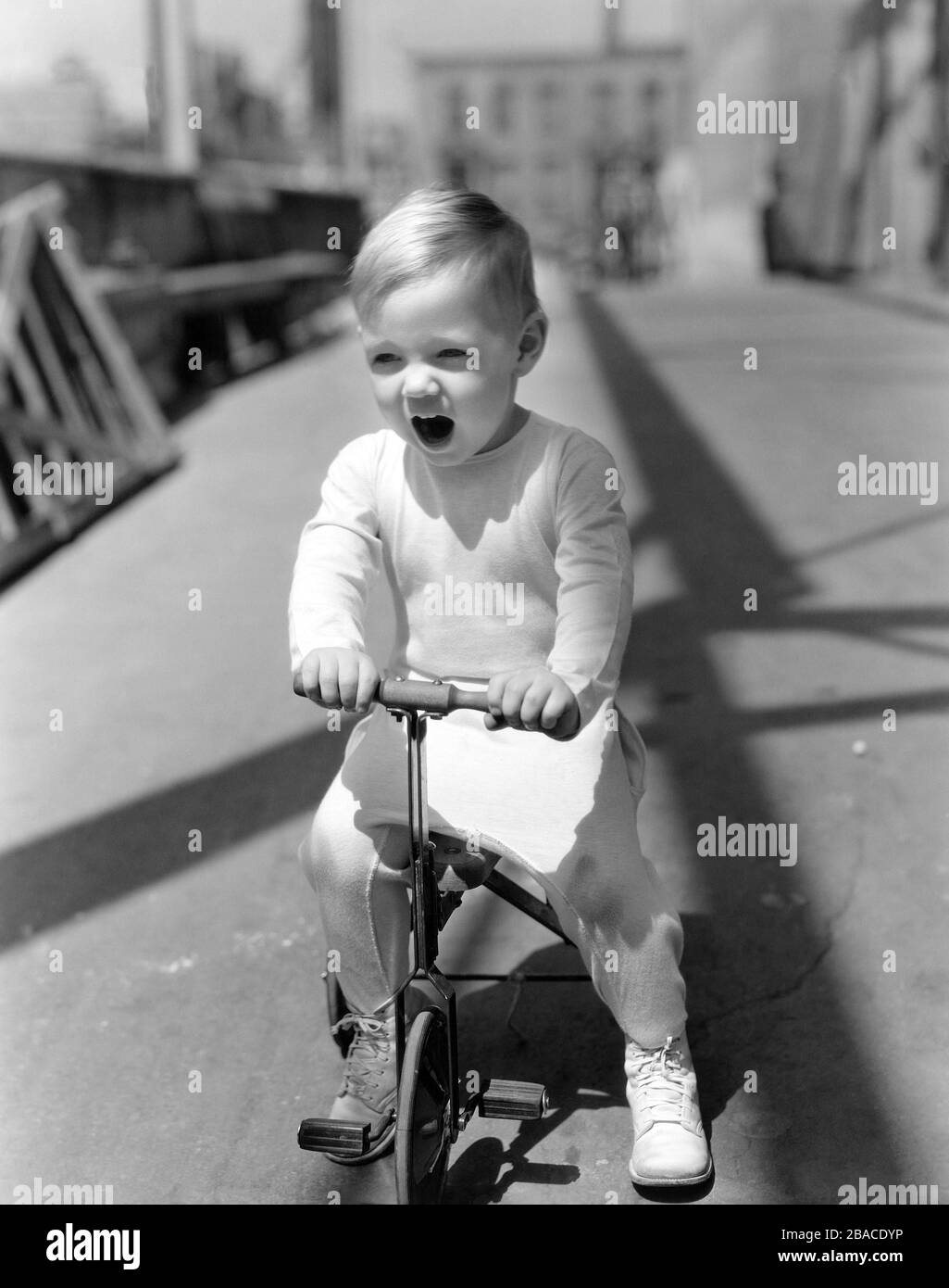 Yawning boy riding tricycle (OV2019 517) (OV2019 517 Stock Photo Alamy