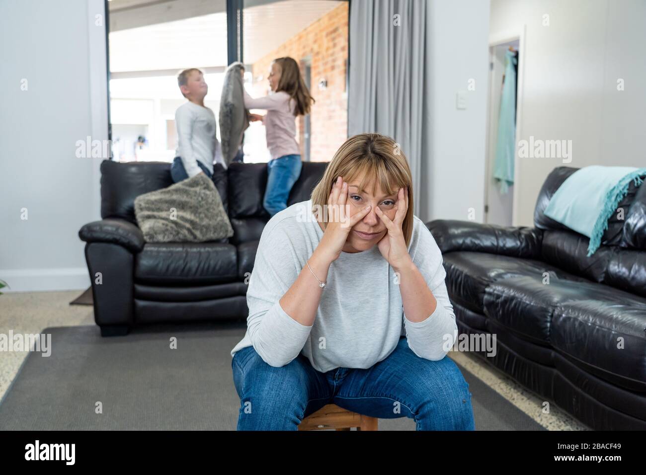 Stressed out parents struggling with having the children at home during Coronavirus self-isolation. Mother and father trying to cope with anxious kids Stock Photo
