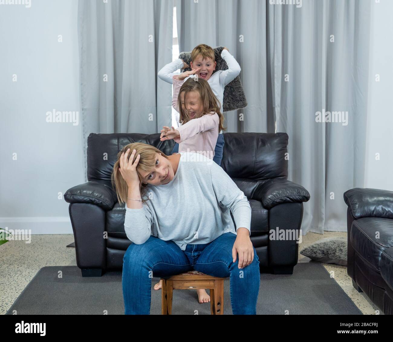 Stressed out parents struggling with having the children at home during Coronavirus self-isolation. Mother and father trying to cope with anxious kids Stock Photo