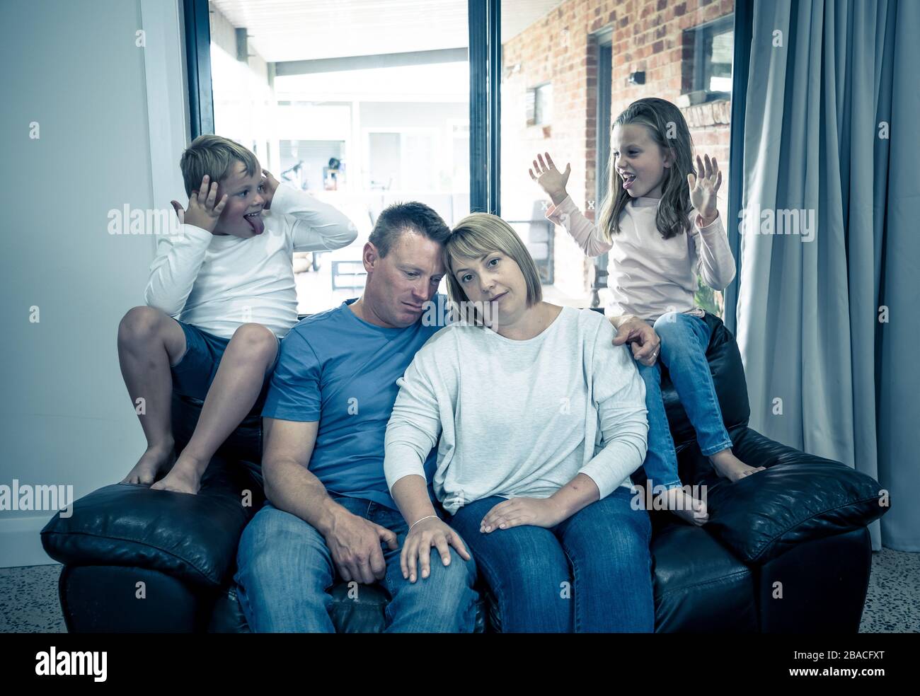 Stressed out parents struggling with having the children at home during Coronavirus self-isolation. Mother and father trying to cope with anxious kids Stock Photo