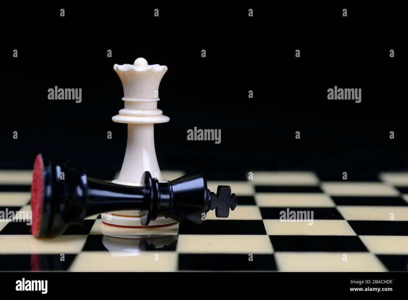 Two chessmen on chessboard, Queen defeats king, Germany Stock Photo