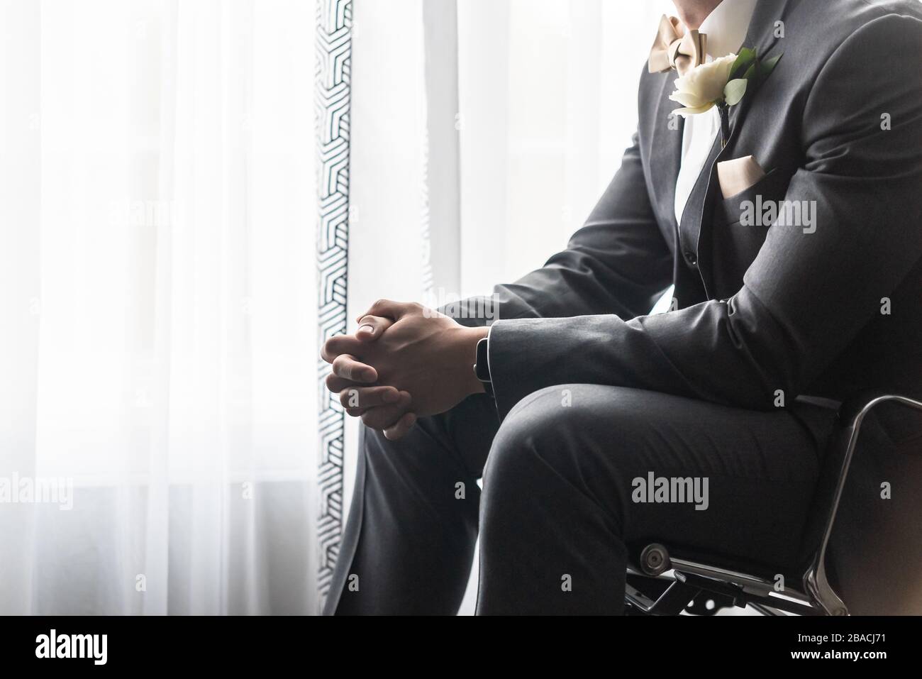 Handsome groom in a black suit praying before the wedding ceremony ...