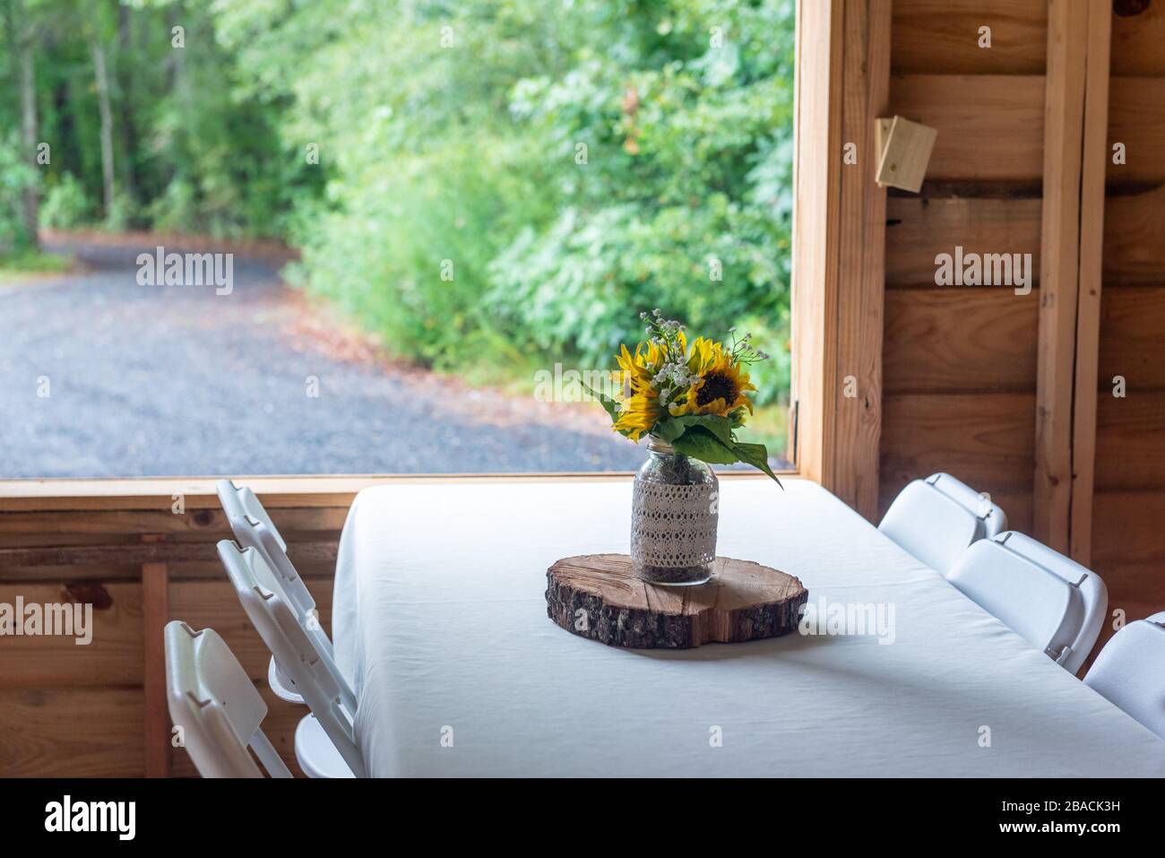 Bouquet with beautiful sunflowers in a glass vase on the table at a ...
