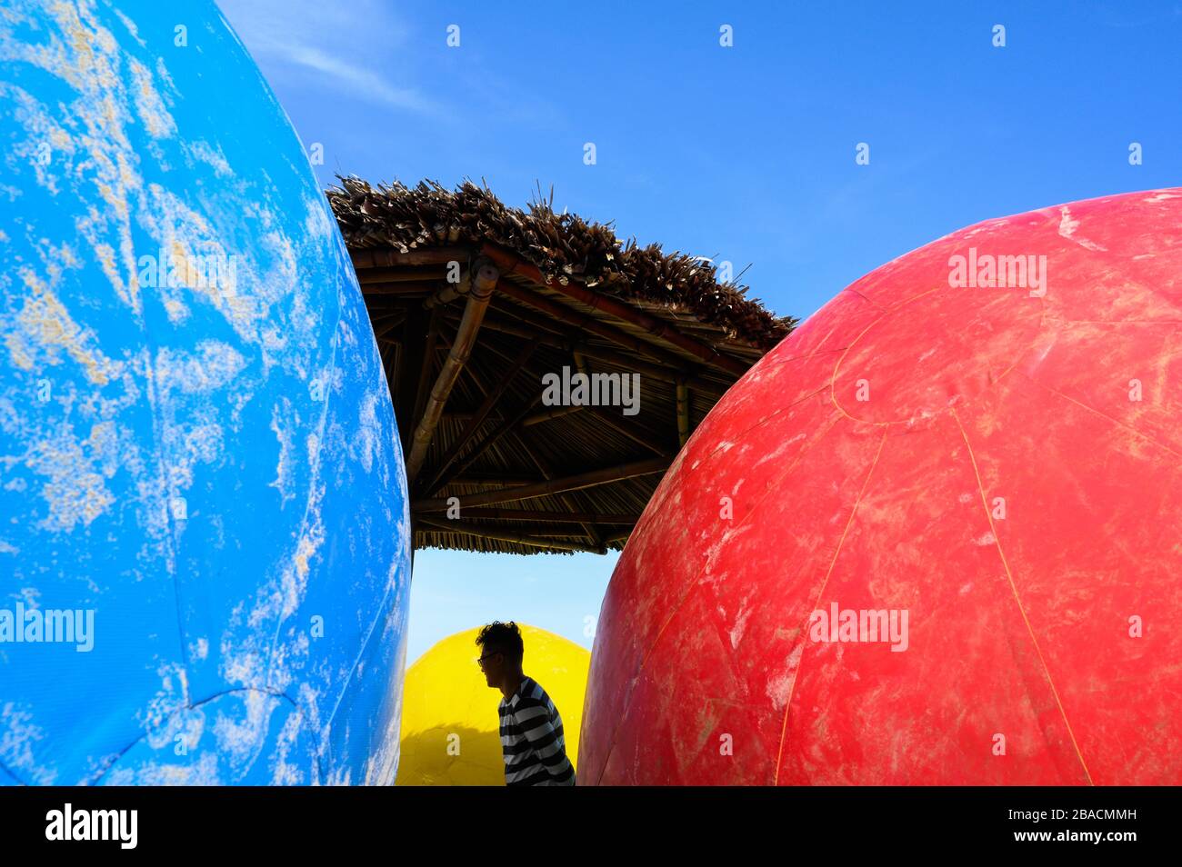 Silhouette of a man among giant beach balls, Back Beach, Vung Tau, Vietnam Stock Photo