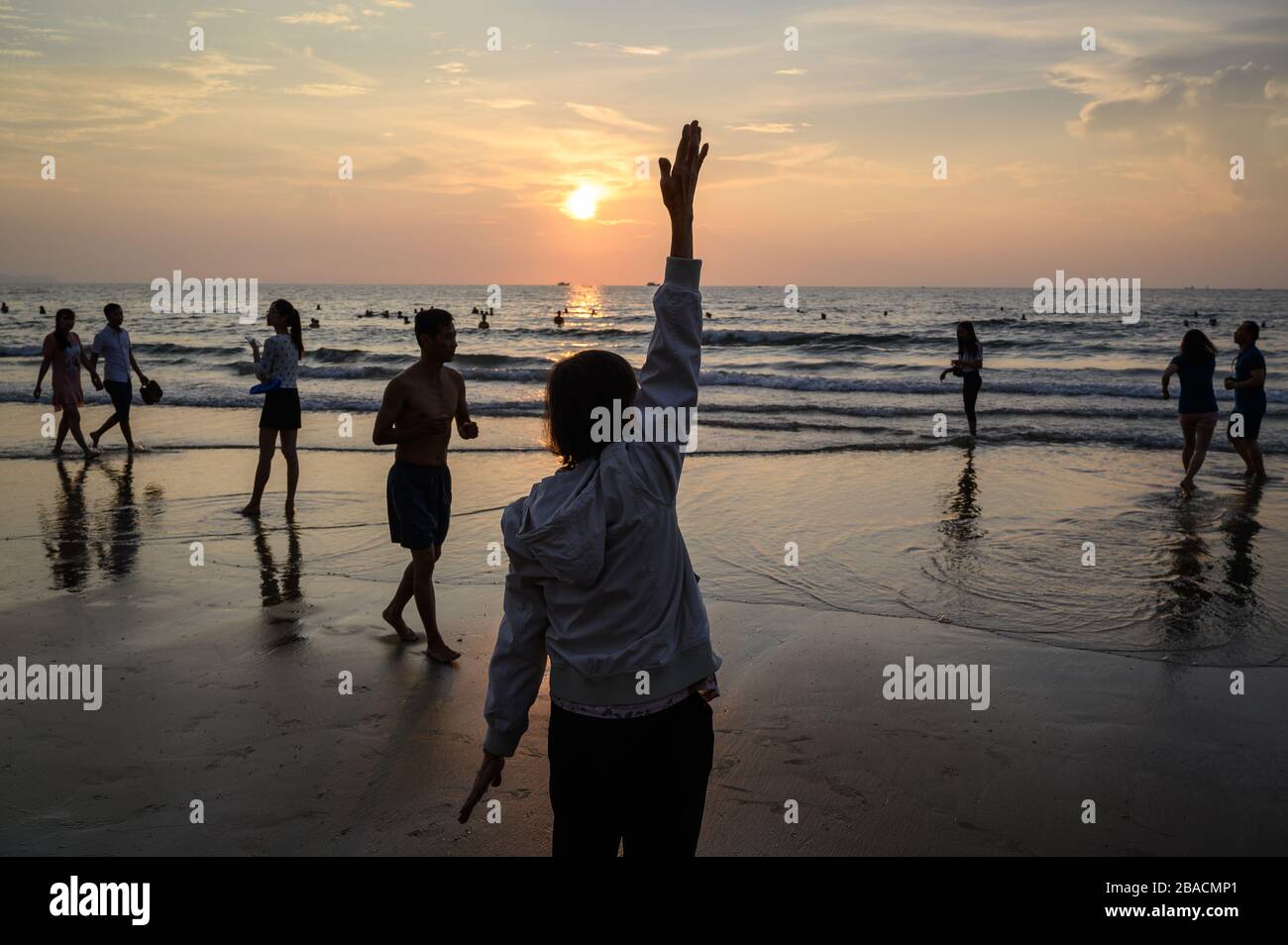 Vietnamese woman doing exercises in the early morning on Back Beach, Vung Tau, Vietnam Stock Photo