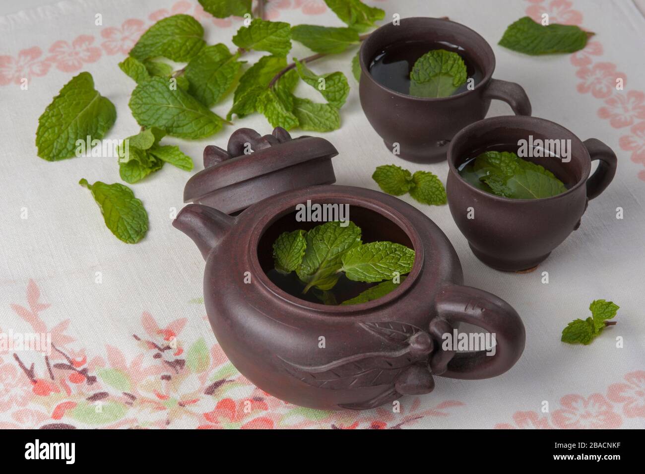 Yixing clay teapot and two tea cups with mint leaves Stock Photo