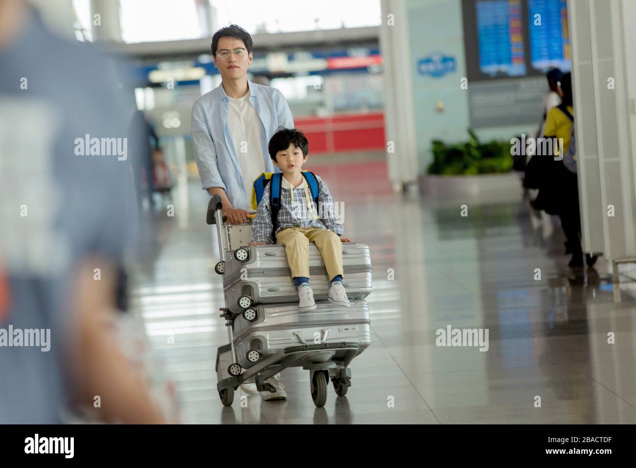 Father and son in the airport lounge wheeled luggage Stock Photo Alamy