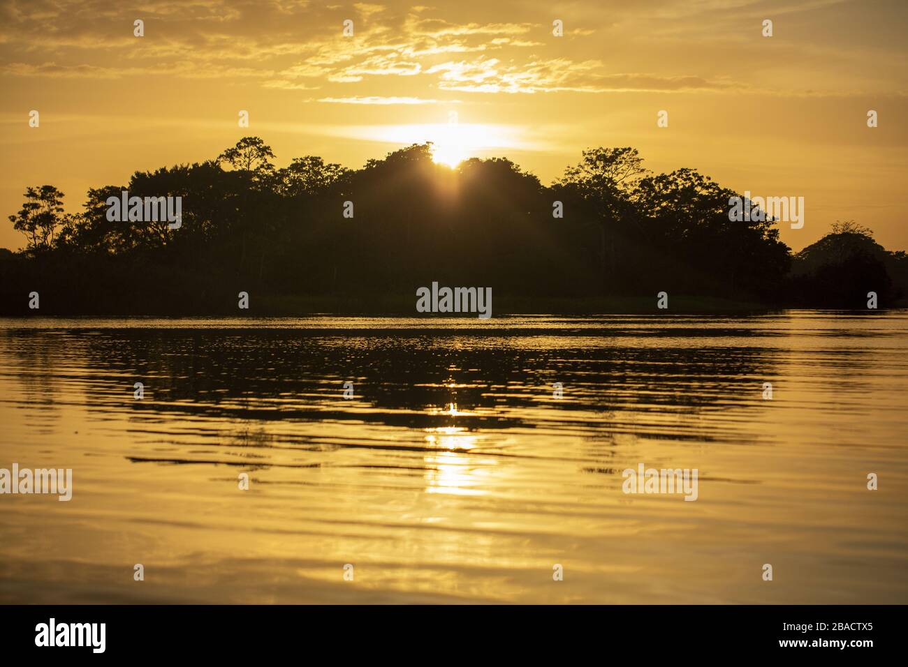 Beautiful scenery of the sunset reflecting on the sea surrounded by a ...