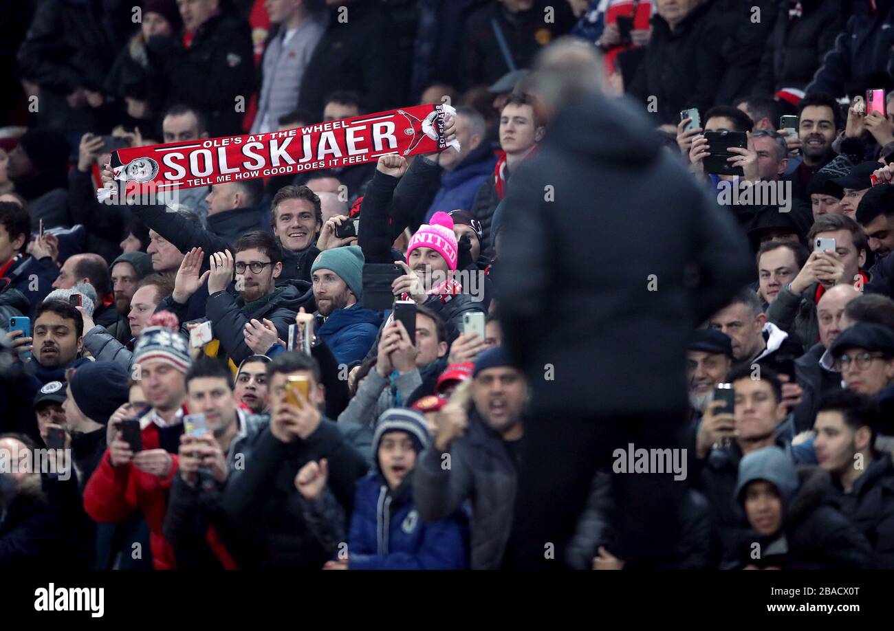 A Manchester United fan holds up a Ole Gunnar Solskjaer scarf in the stands that reads Ole’s at the wheel, tell me how good does it feel Stock Photo