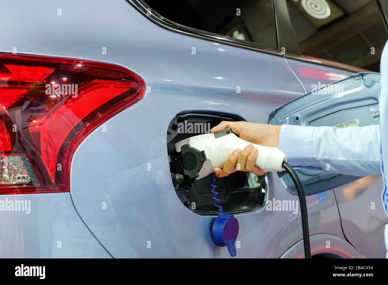 Close-up asia women hands who are fueling a new vehicle electrification via rechargeable electricity machine Stock Photo