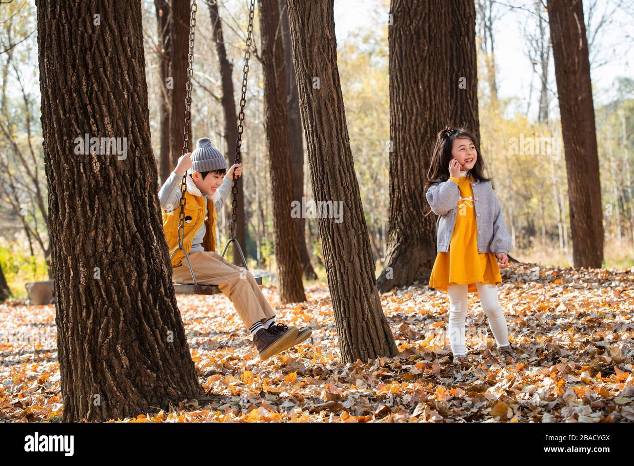 Outdoor little boy on the swings, the little girl go sight-seeing Stock Photo