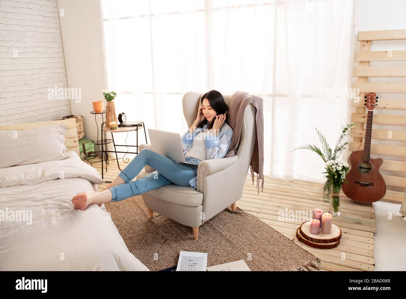 Happy young woman sitting on the sofa using laptops Stock Photo - Alamy