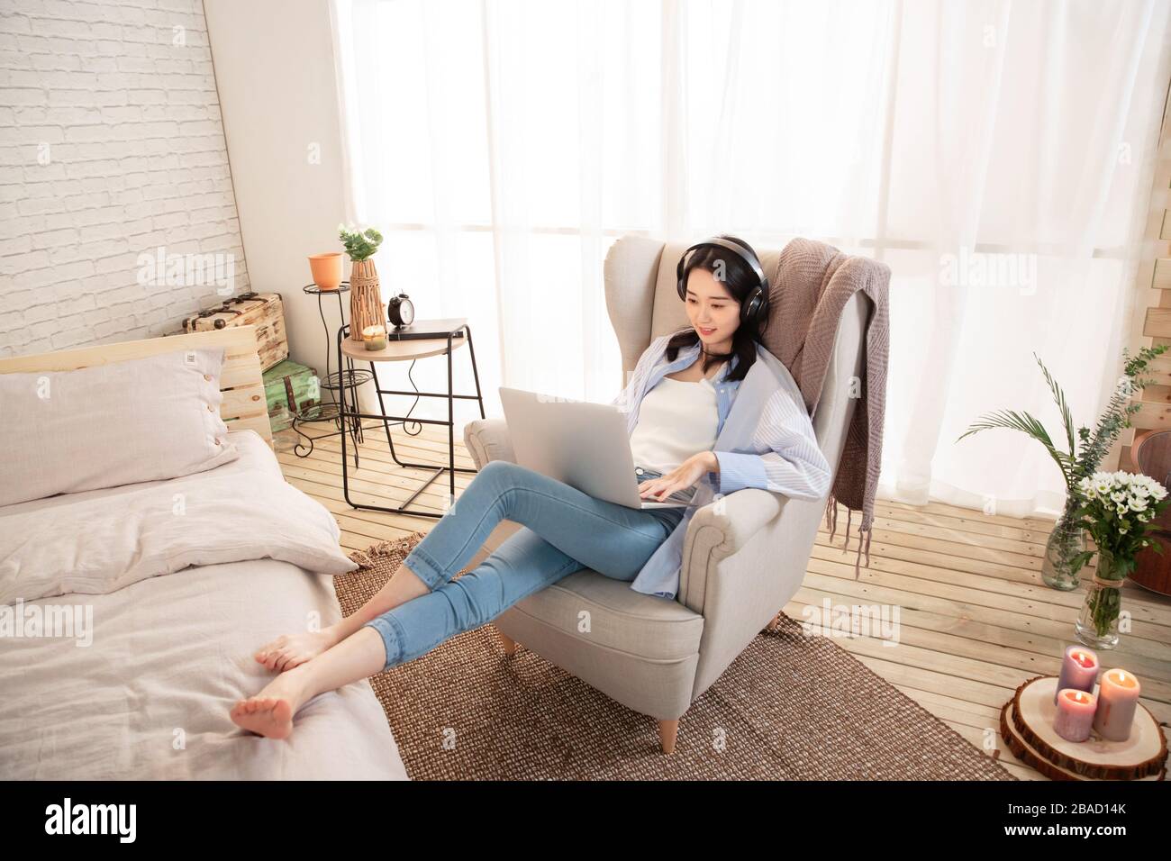 Happy young woman sitting on the sofa using laptops Stock Photo - Alamy