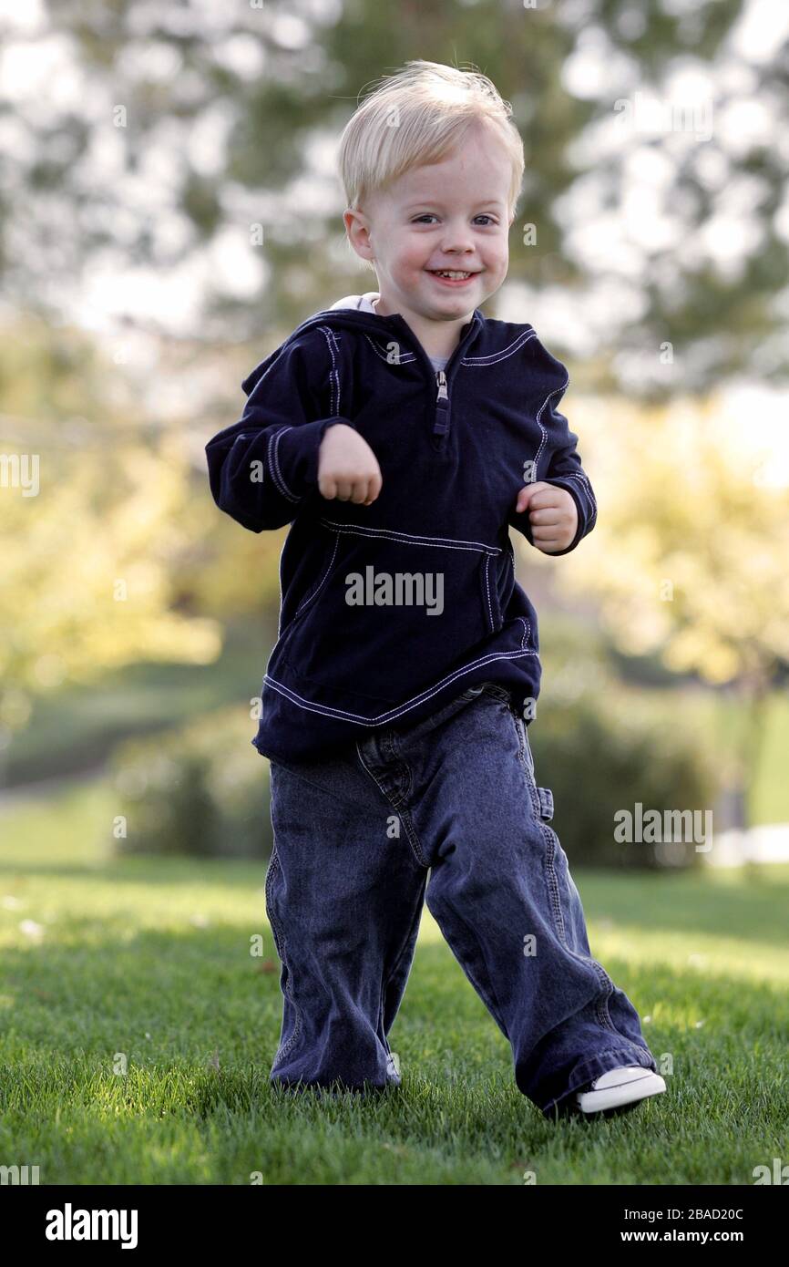 A young boy runs in a park having fun. Stock Photo