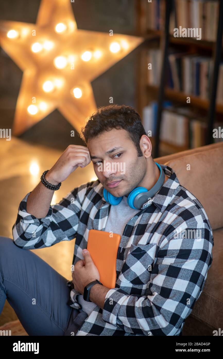 Handsome man in a checkered shirt looking thoughtful Stock Photo