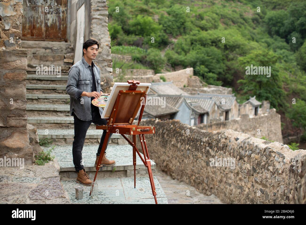 Young Chinese artist painting outdoors Stock Photo
