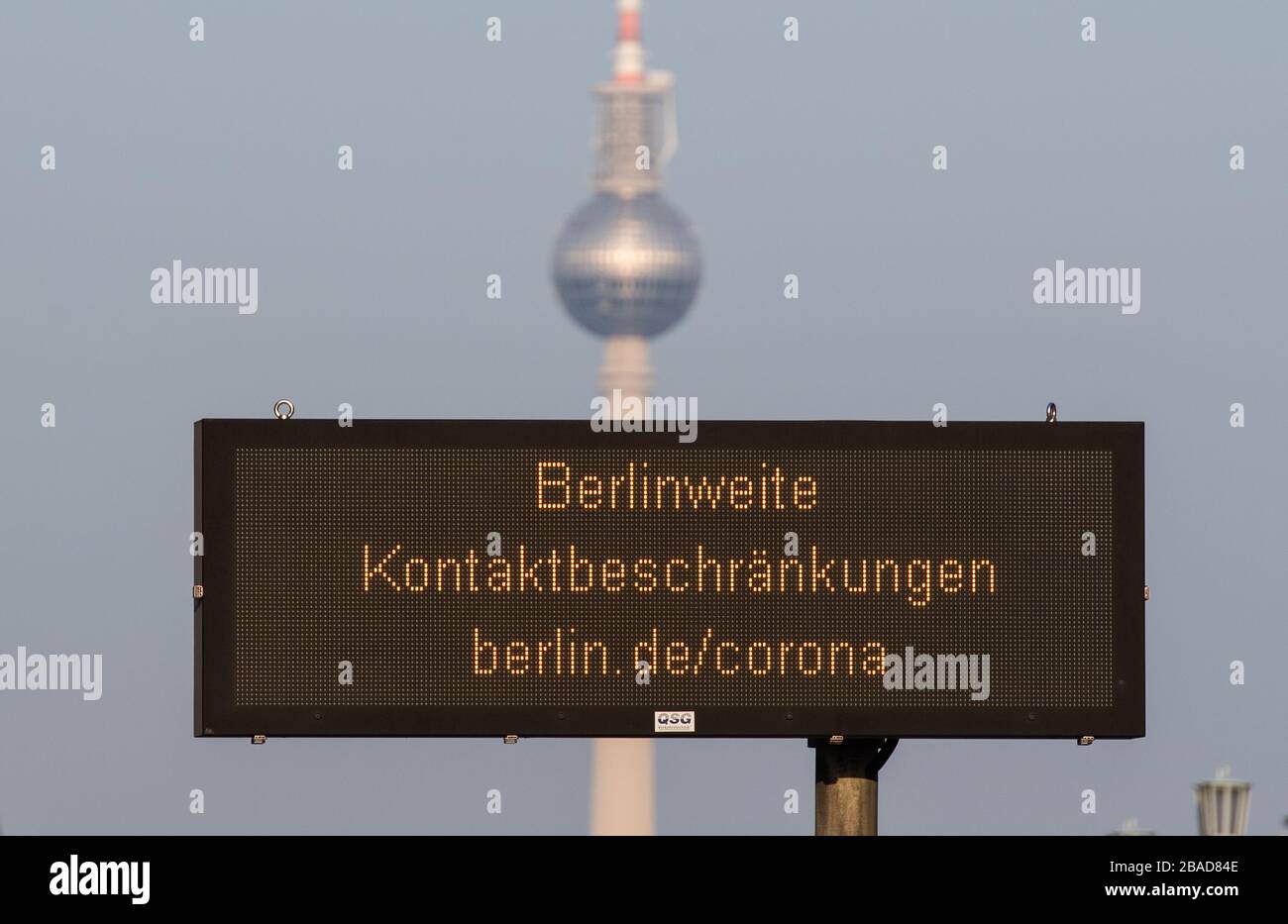 Berlin, Germany. 27th Mar, 2020. On Frankfurter Allee there is a notice board with the inscription ''Berlinweite Kontaktbeschränkungen berlin.de/corona'. In the background is the television tower. In order to slow down the spread of the corona virus, public life in Berlin has also been considerably restricted. Credit: Christophe Gateau/dpa/Alamy Live News Stock Photo